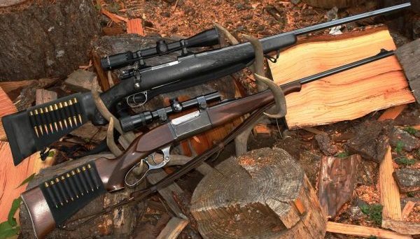 The rifle on top has a black stock, telescopic sight and is a bolt-action. The one on the bottom is a lever-action, with a scope. Is one a "sniper" rifle and the other a "hunting" rifle? (Dave Workman photo)